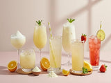 Assorted lemonade drinks with fruits and straws on a pink background made from freeze dried sugarcane powder