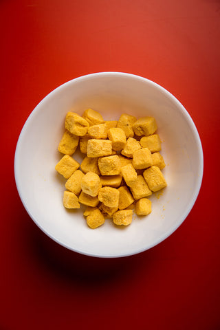 Multiple packages of freeze dried mango dices with visible brand logo on a white background